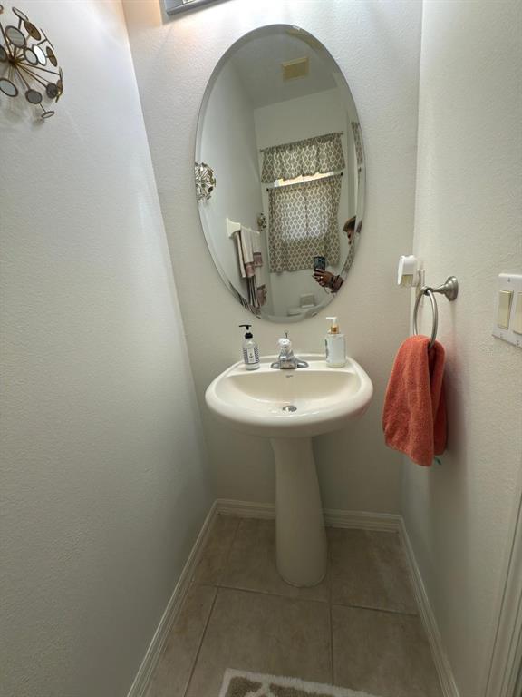 879 Assembly Court Reunion, FL 34747 - Photo 23 of 46 a bathroom with a sink and mirror