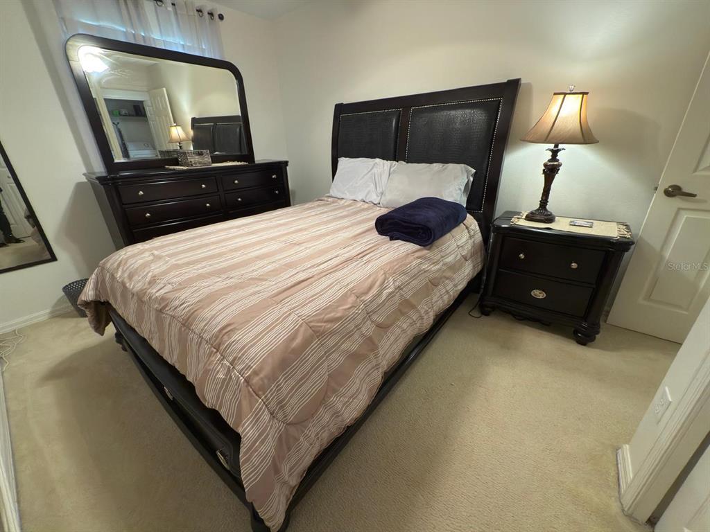 879 Assembly Court Reunion, FL 34747 - Photo 30 of 46 a bedroom with a bed and a mirror on dresser