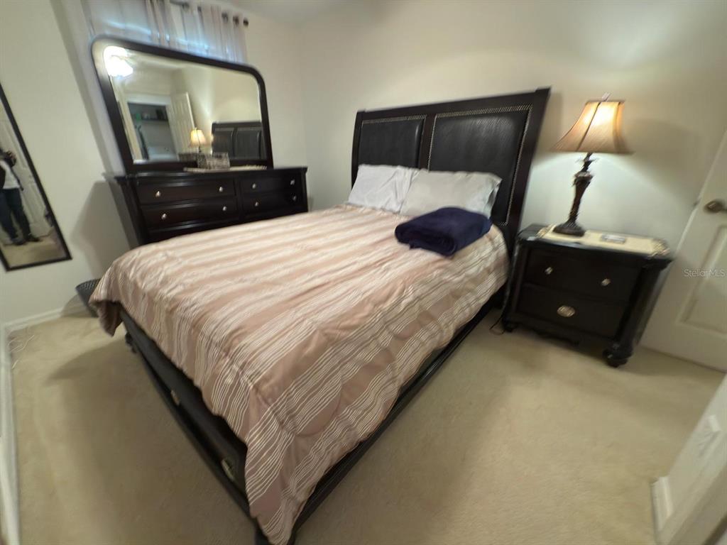 879 Assembly Court Reunion, FL 34747 - Photo 33 of 46 a bedroom with a bed and a lamp with mirror