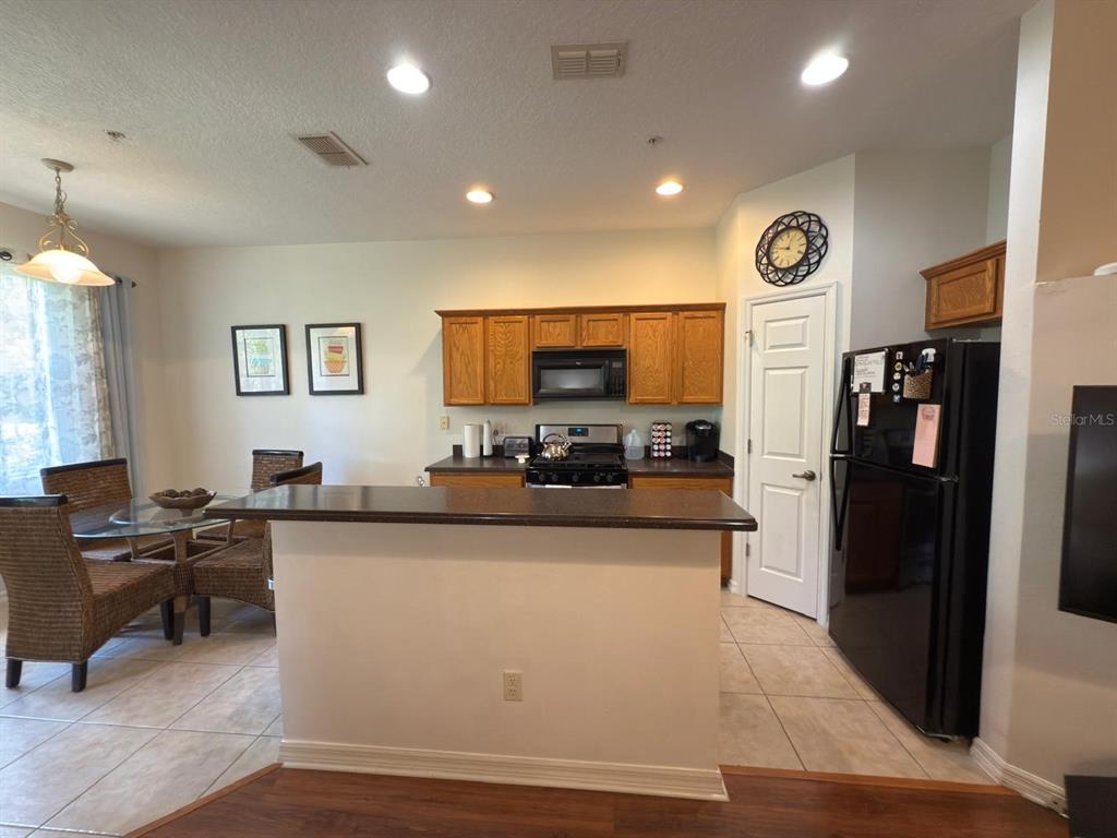 879 Assembly Court Reunion, FL 34747 - Photo 8 of 46 a large white kitchen with cabinets a sink and a refrigerator