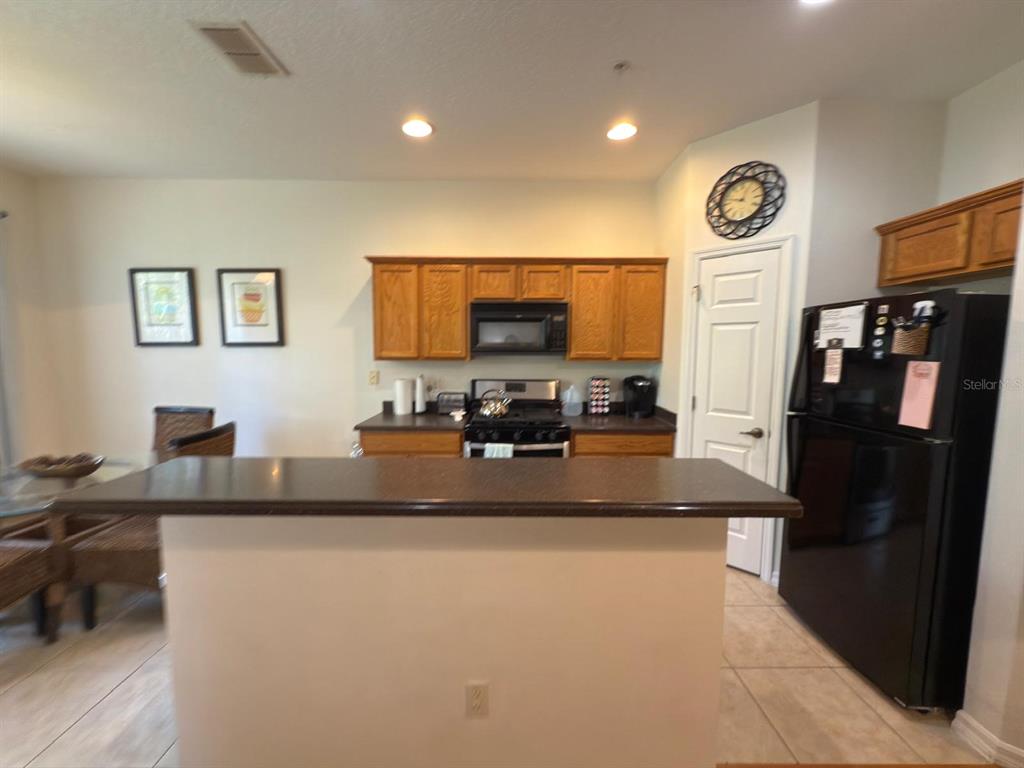 879 Assembly Court Reunion, FL 34747 - Photo 10 of 46 a kitchen with stainless steel appliances granite countertop a refrigerator a stove and a sink