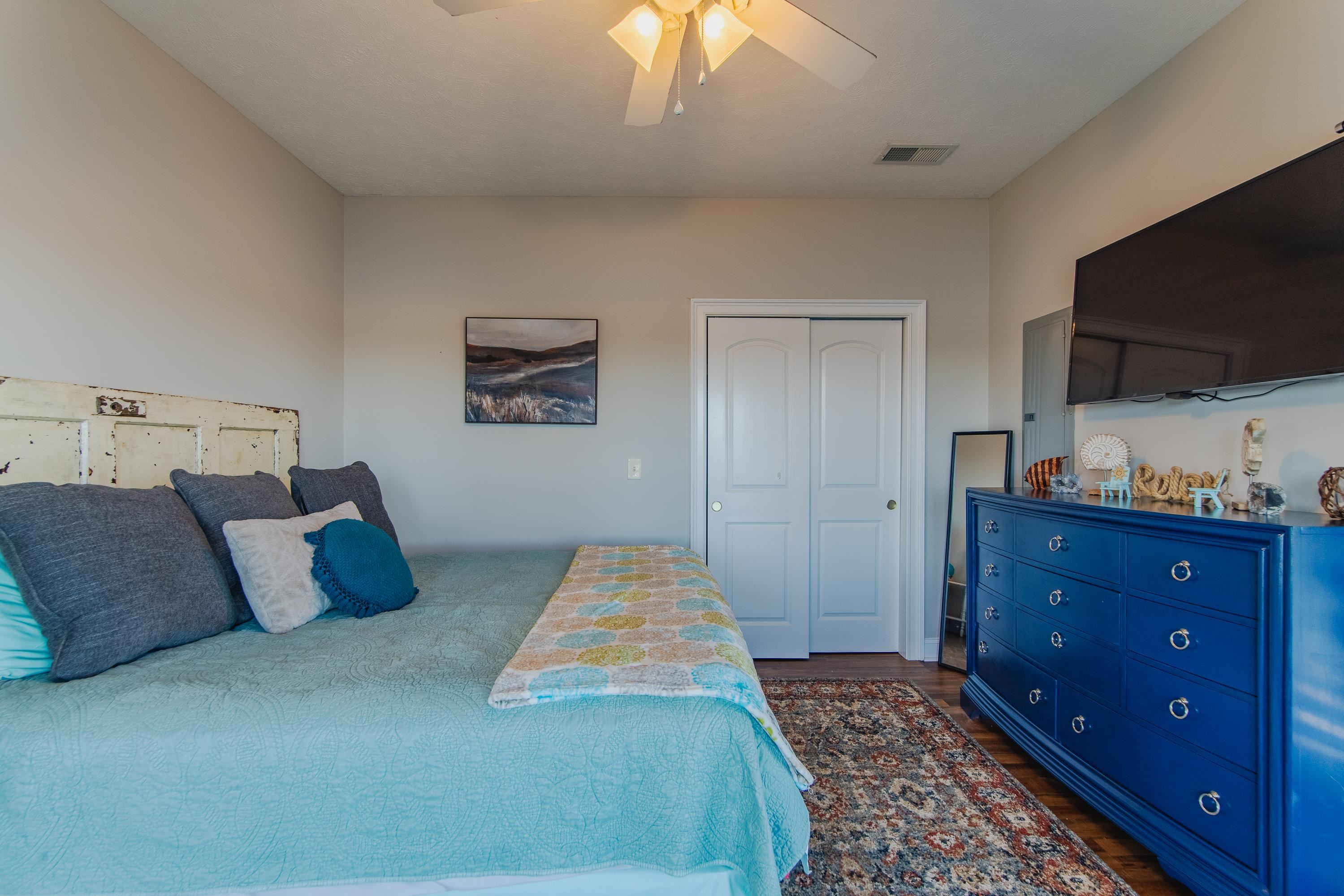 1111 Leaning Trees Lane Adamsville, TN 38310 - Photo 10 of 36 Bedroom with ceiling fan, dark hardwood / wood-style flooring, and a closet