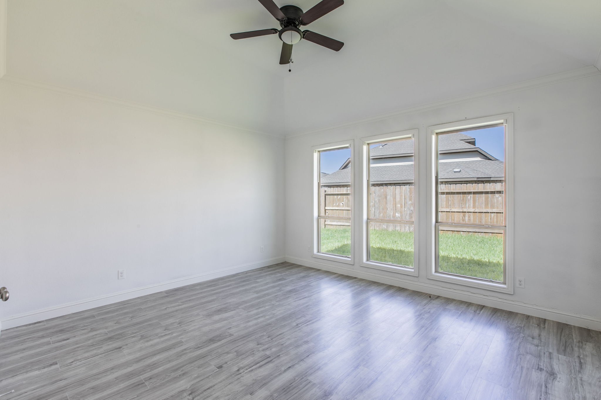 4806 Timber Gate Court Rosharon, TX 77583 - Photo 13 of 36 an empty room with wooden floor fan and windows