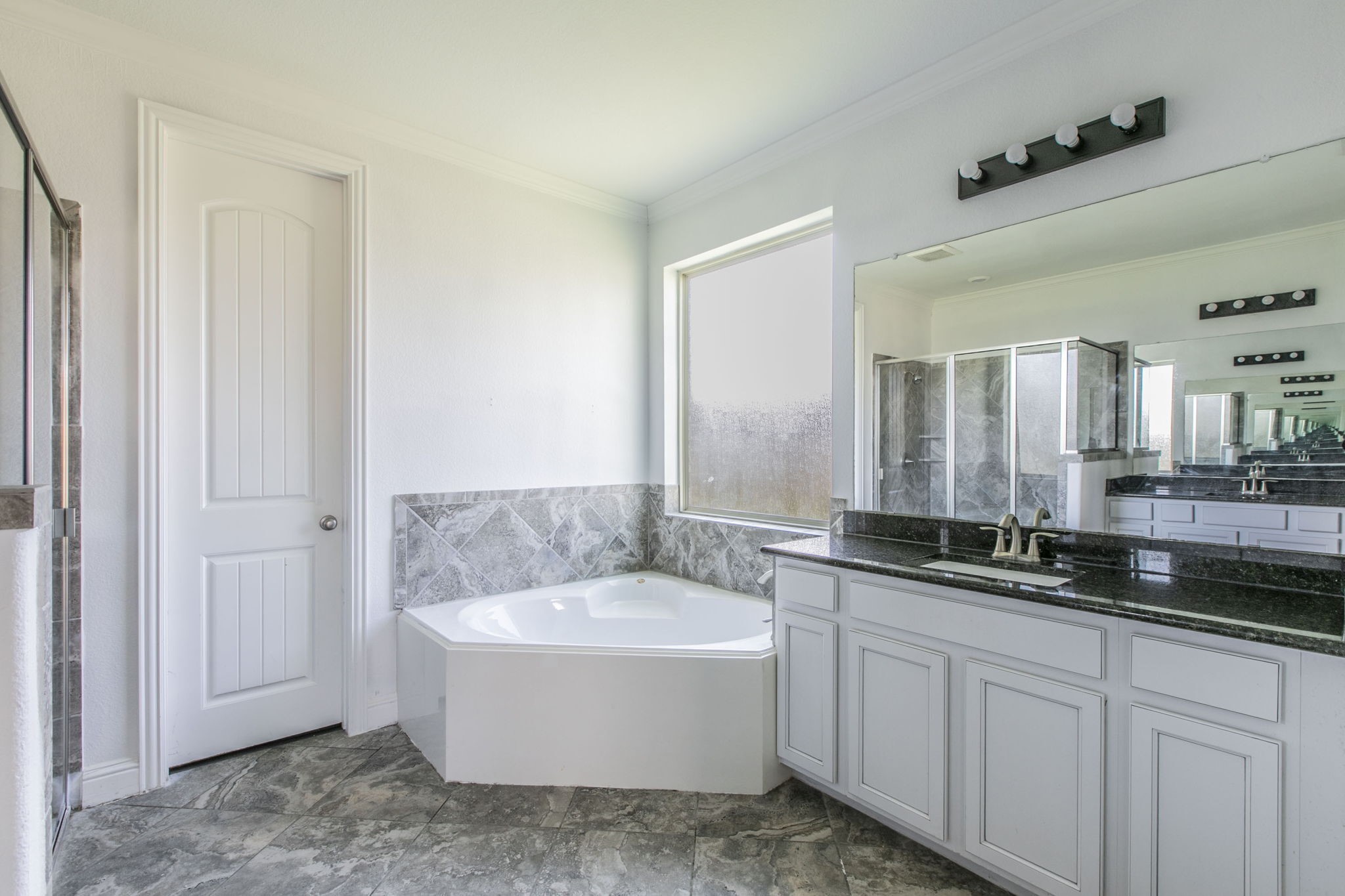 4806 Timber Gate Court Rosharon, TX 77583 - Photo 18 of 36 a bathroom with a bathtub a double vanity sink and mirror