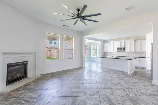 a view of an empty room with a fireplace and a window