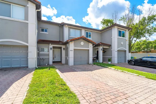 a front view of a house with a yard and garage