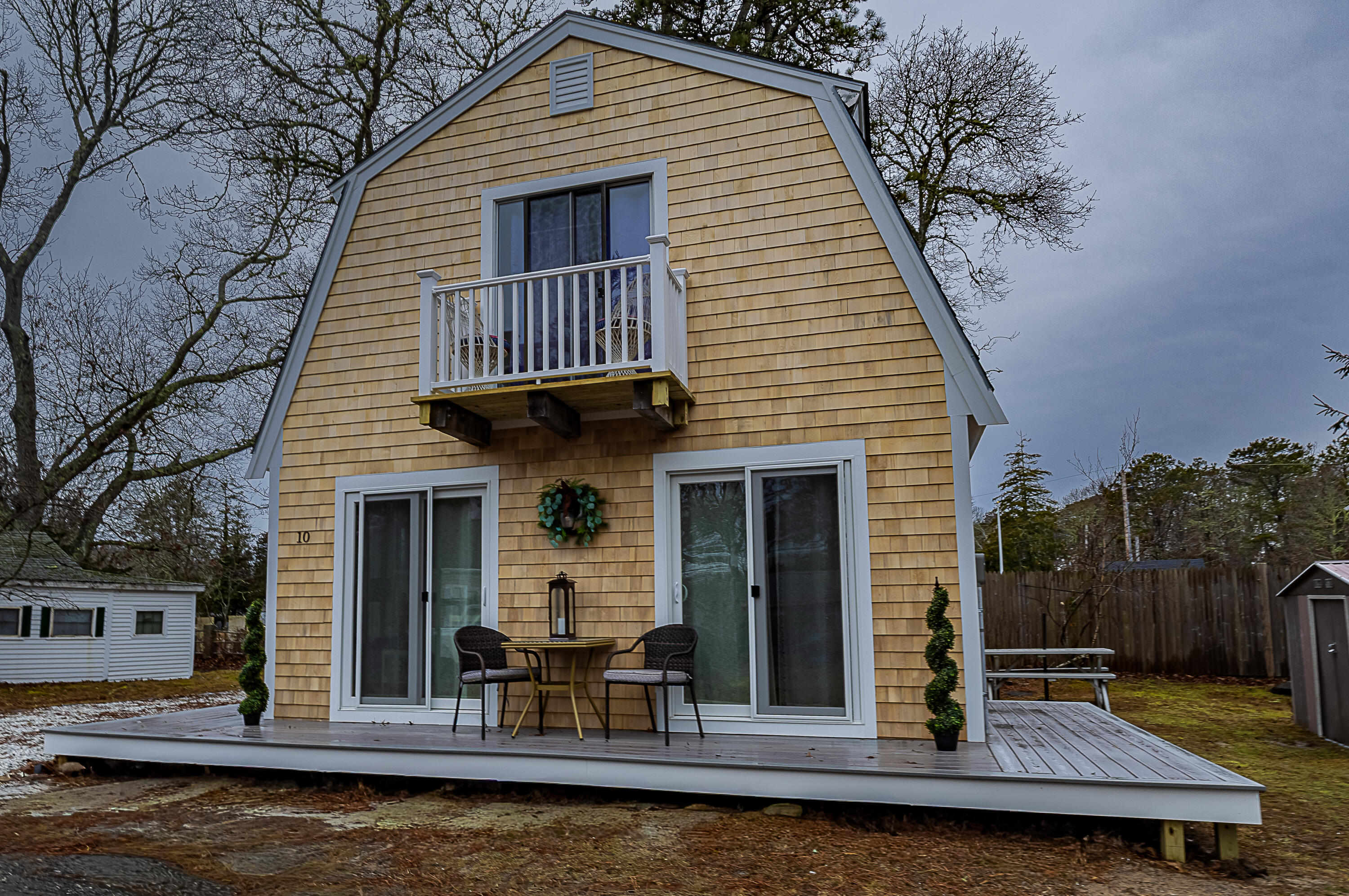 a view of house with pool and chairs