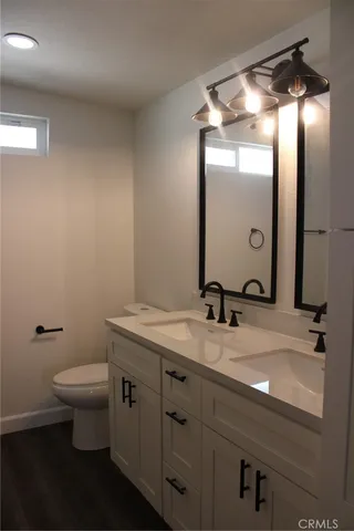 a bathroom with a granite countertop sink toilet and a mirror