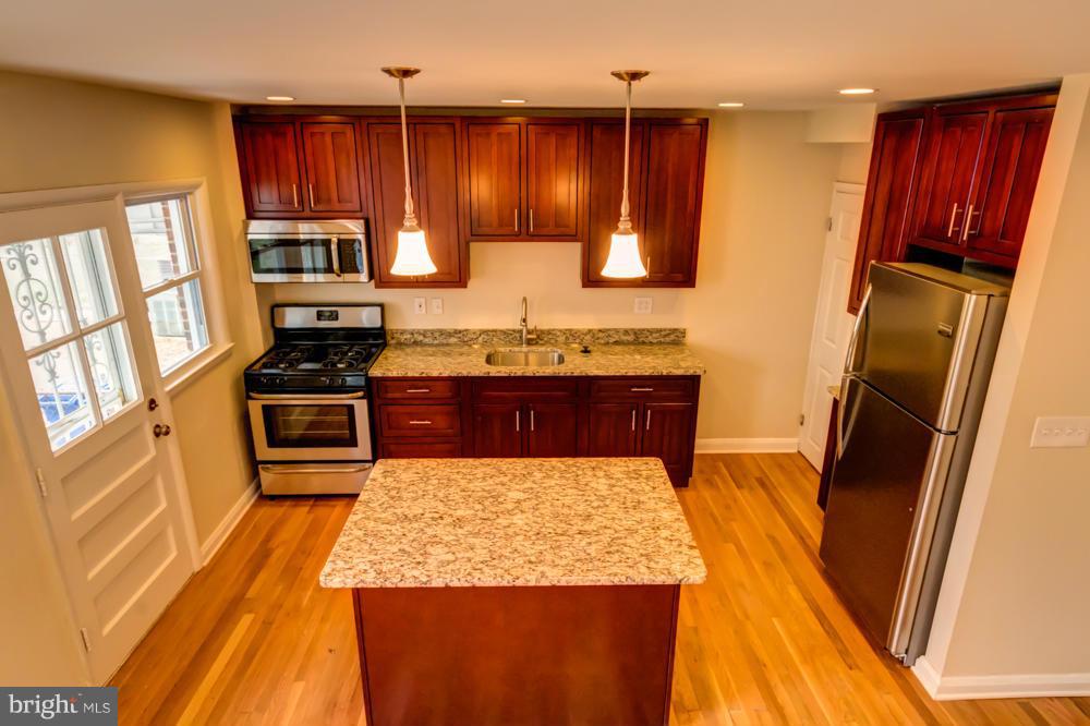 6146 Marlora Road Baltimore, MD 21239 - Photo 1 of 27 a kitchen with stainless steel appliances granite countertop refrigerator stove microwave and sink