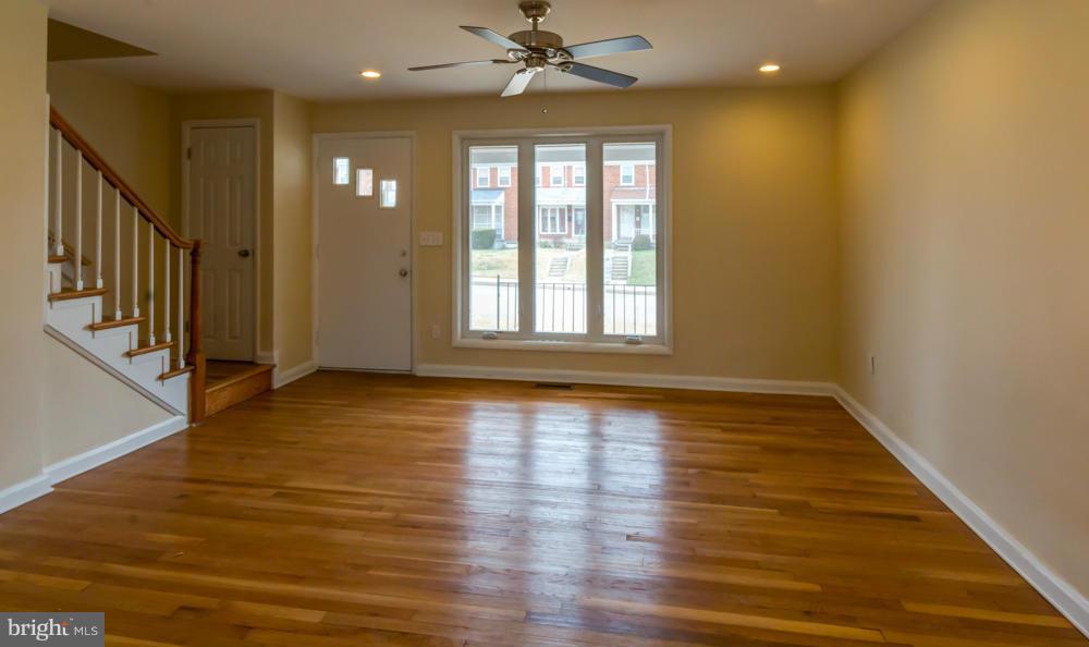 6146 Marlora Road Baltimore, MD 21239 - Photo 8 of 27 a view of an empty room with wooden floor and a window