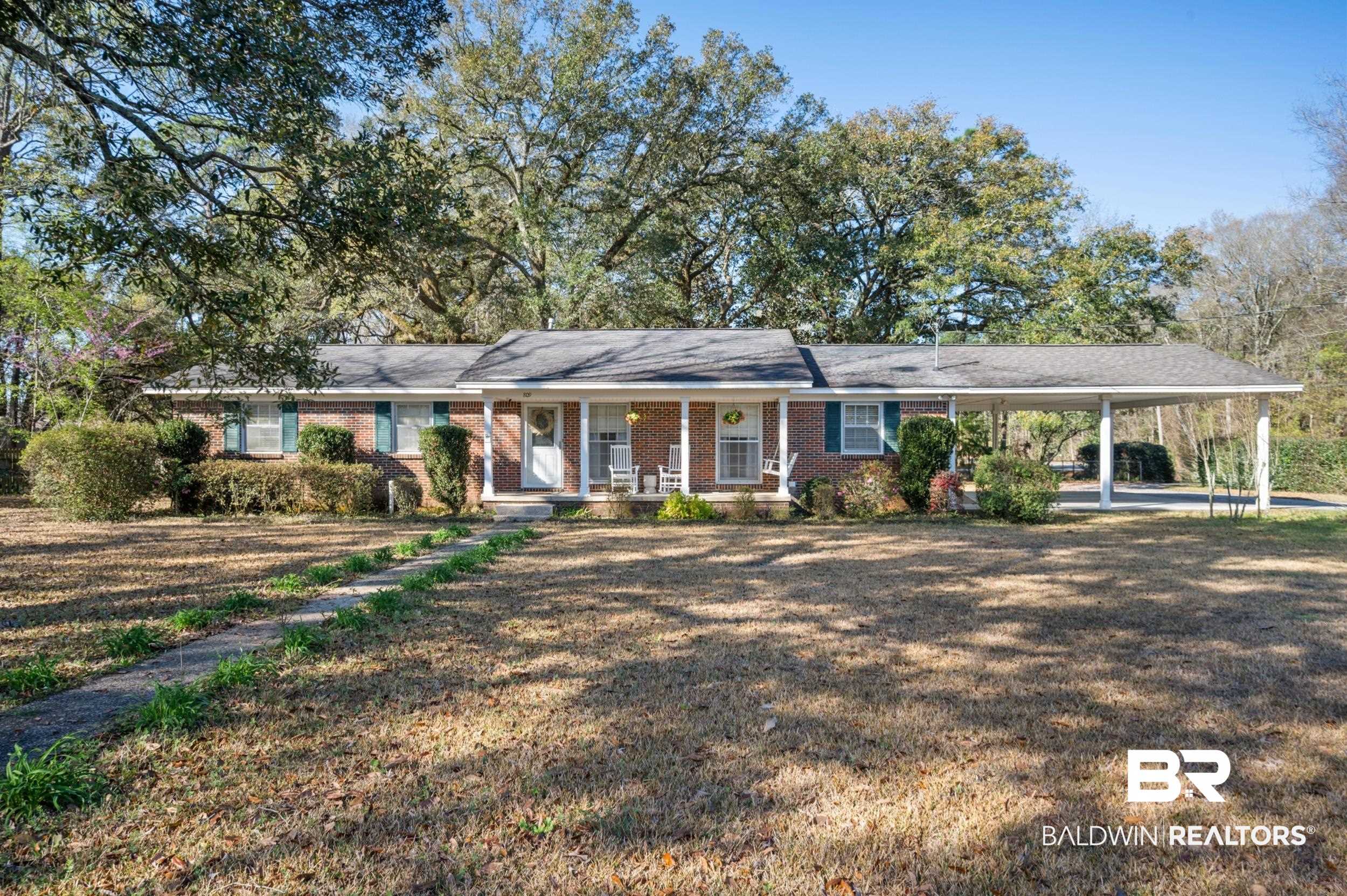 809 Moog Avenue Bay Minette, AL 36507 - Photo 1 of 33 Ranch-style home with a porch, a carport, brick siding, and a front lawn