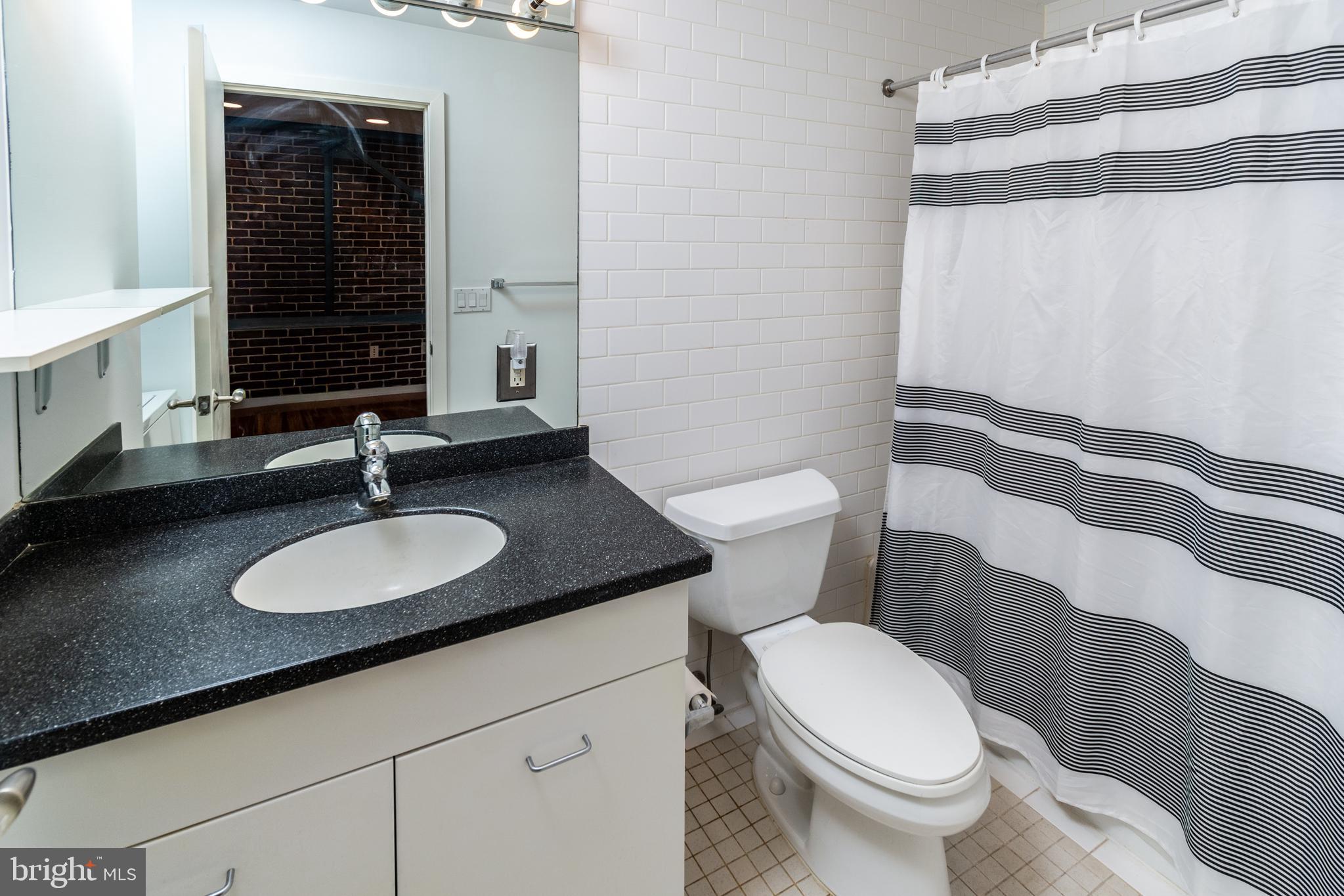36 Moore Street, Unit 8 Princeton, NJ 08542 - Photo 24 of 35 a bathroom with a granite countertop sink and a mirror