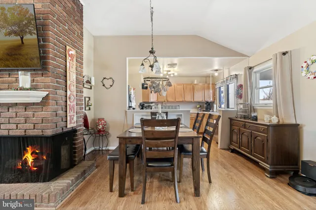 a living room with furniture dining table a flat screen tv and a large window