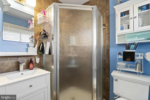 a bedroom with a bed and a flat tv screen on dresser
