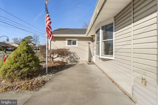 a view of a house with a small yard and potted plants