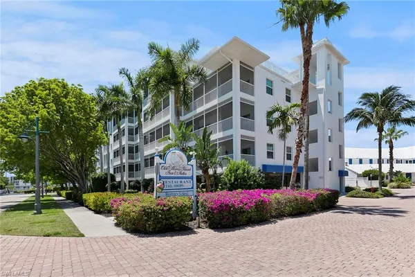 a front view of multi story residential apartment building with yard and sign board