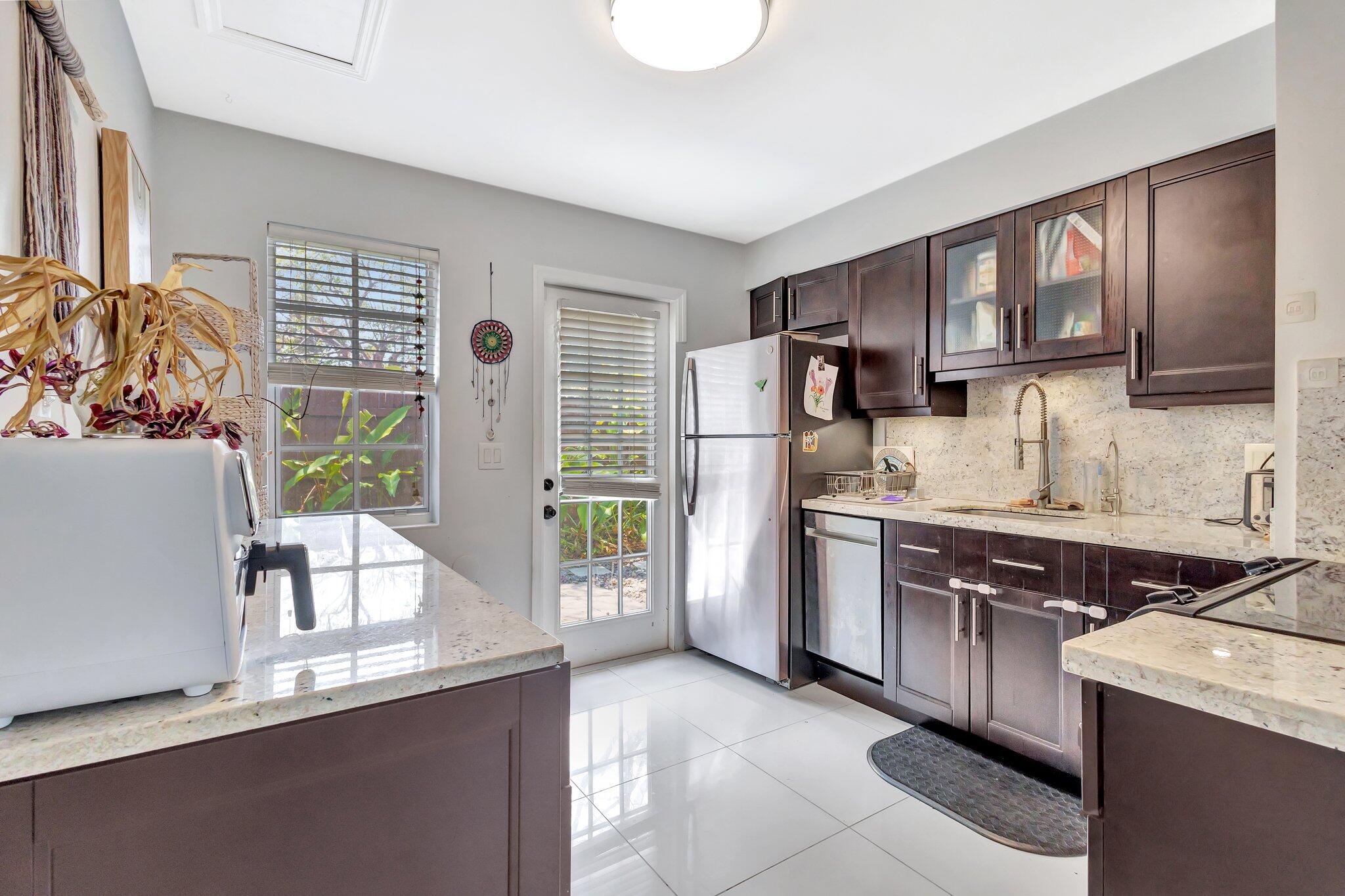 227 Northeast 12th Street, Unit 2 Delray Beach, FL 33444 - Photo 13 of 24 a kitchen with stainless steel appliances granite countertop a refrigerator a stove a sink and a microwave