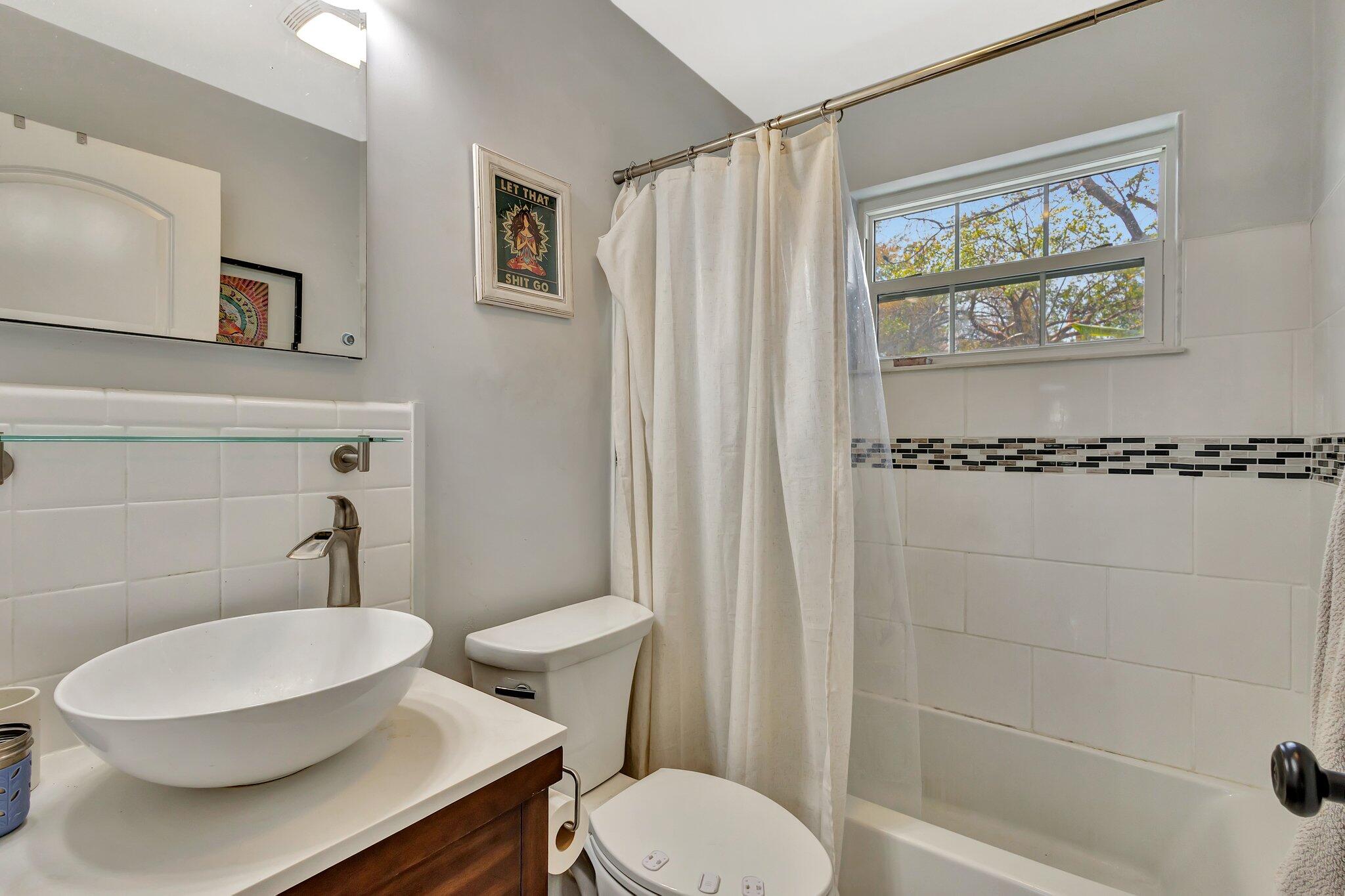 227 Northeast 12th Street, Unit 2 Delray Beach, FL 33444 - Photo 7 of 24 a bathroom with a toilet a sink and a shower