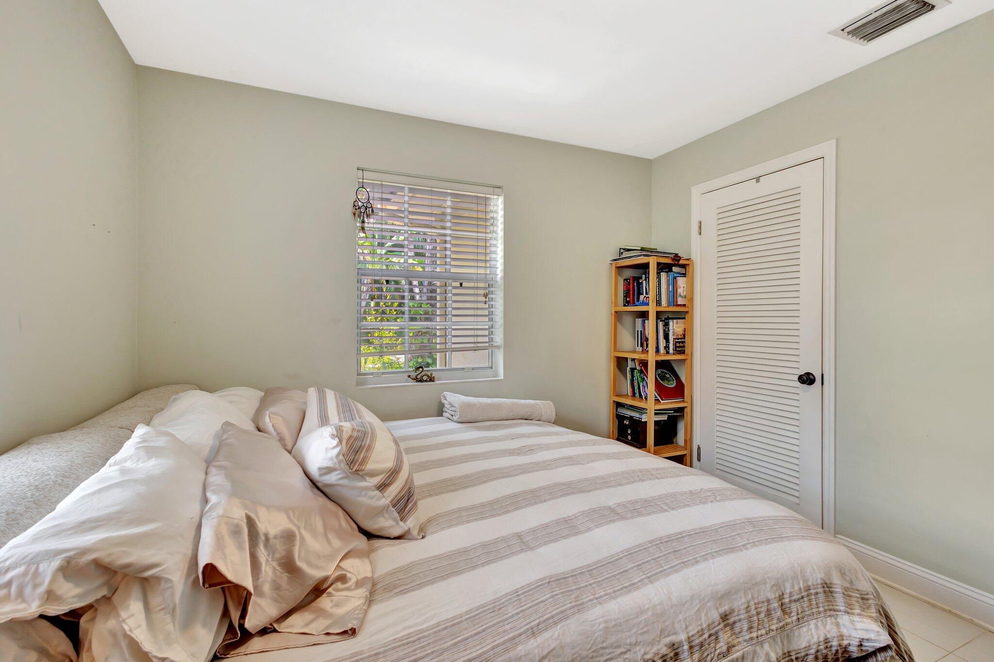 227 Northeast 12th Street, Unit 2 Delray Beach, FL 33444 - Photo 9 of 24 a bedroom with a bed and a book shelf