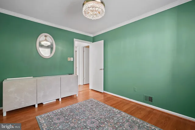 a view of a room with wooden floor and white walls