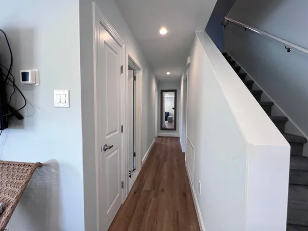 a view of a hallway with wooden floor and staircase
