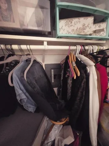 a view of walk in closet with clothes and shoes