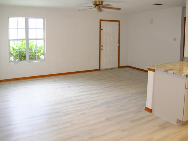 an empty room with a window and wooden floor
