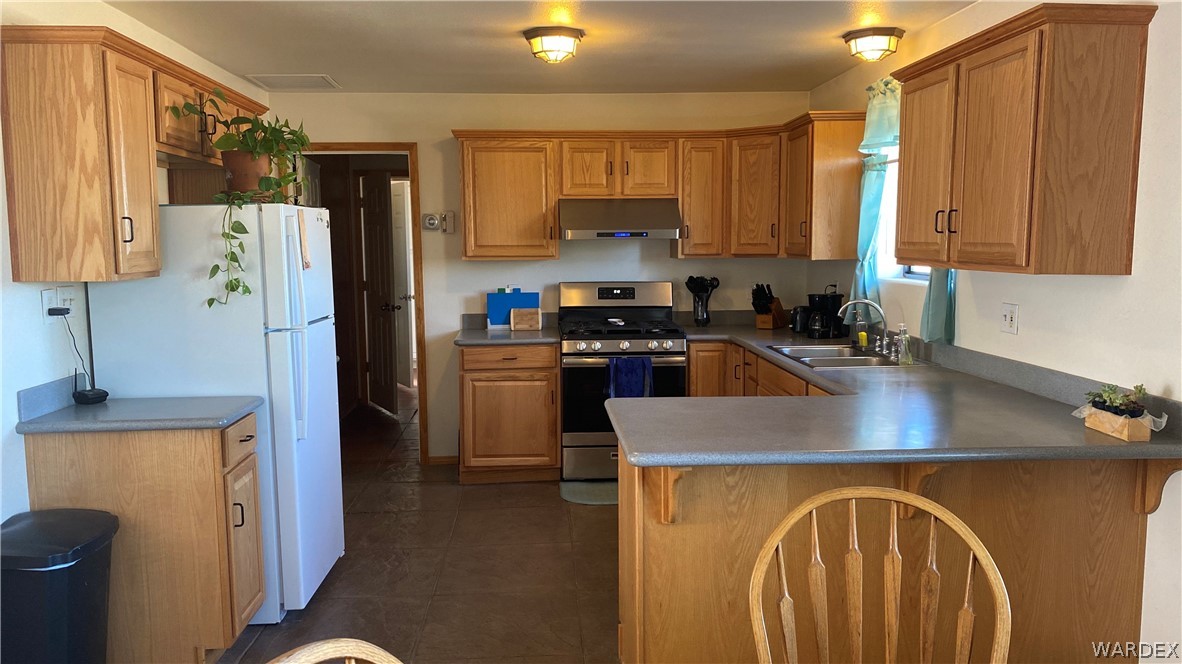 171 South Horn Road Golden Valley, AZ 86413 - Photo 24 of 46 a kitchen with stainless steel appliances granite countertop a refrigerator a sink dishwasher a stove with wooden cabinets