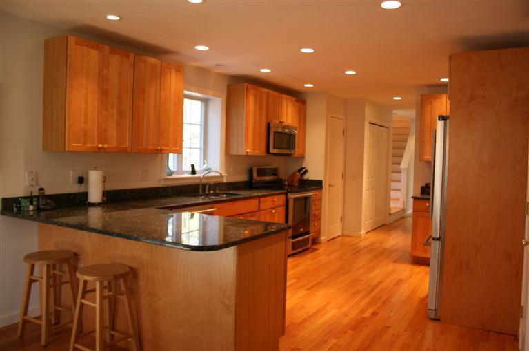 150 Blue Heron Road Wellfleet, MA 02667 - Photo 7 of 35 a kitchen with kitchen island granite countertop a sink and wooden cabinets