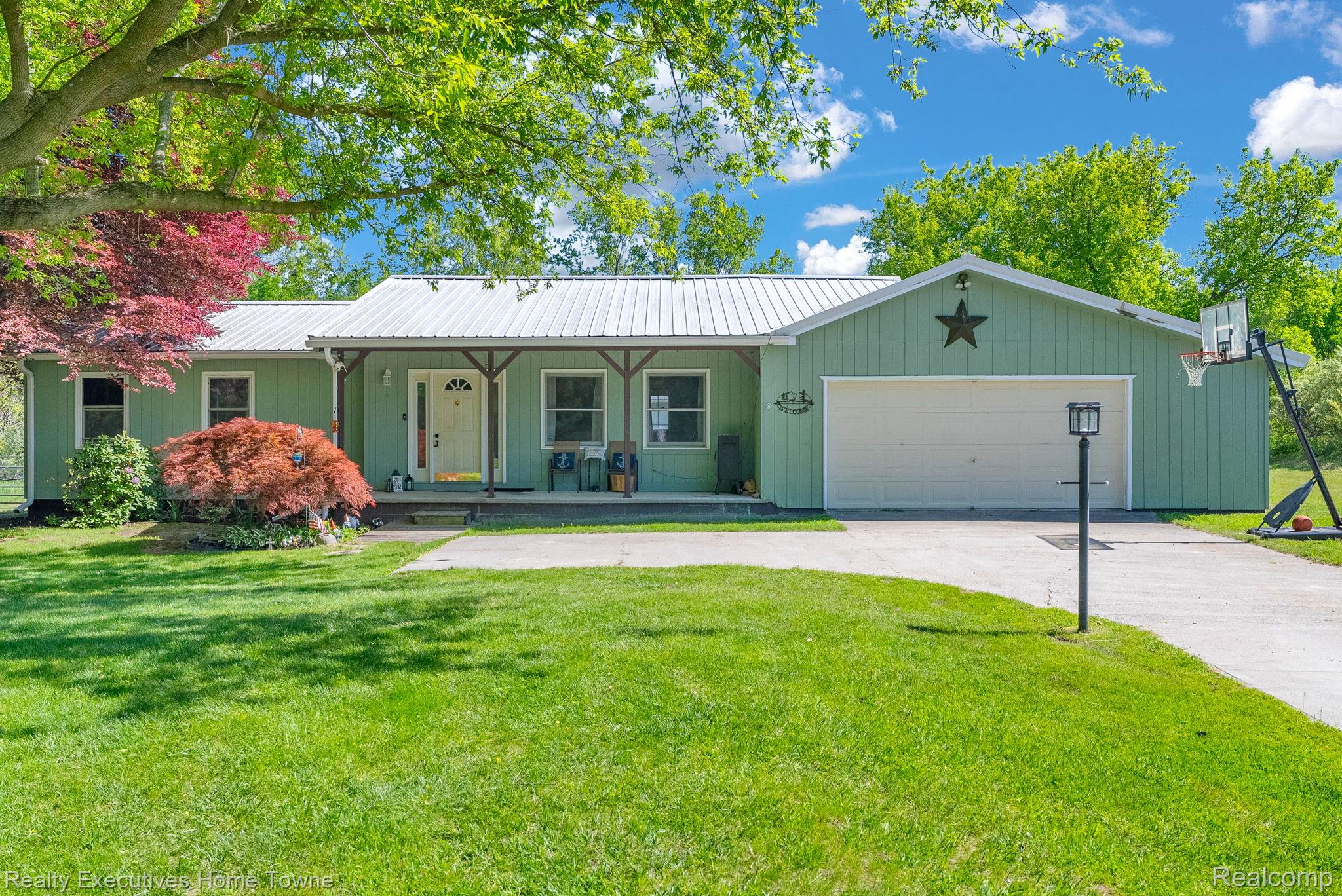 6560 Roach Road Lexington, MI 48450 - Photo 2 of 36 Ranch-style residence featuring a light green exterior with white trim and a prominent metal roof