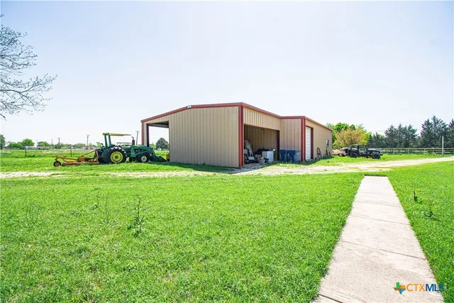 a view of a house with a big yard and potted plants