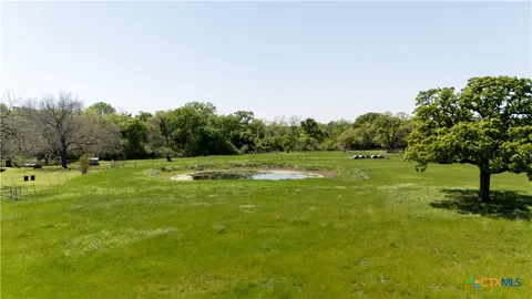 a view of a green field with trees