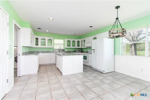 a kitchen with a refrigerator a stove a microwave and island