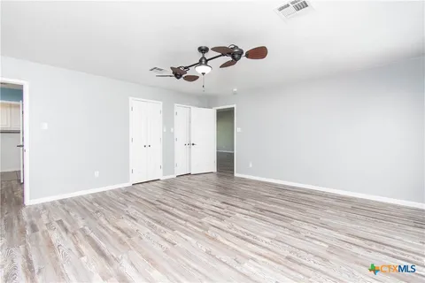 a view of empty room with wooden floor
