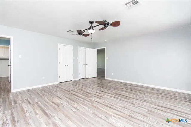 a view of empty room with wooden floor