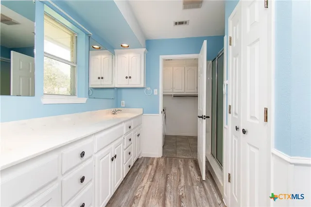 a bathroom with a sink a window and a mirror