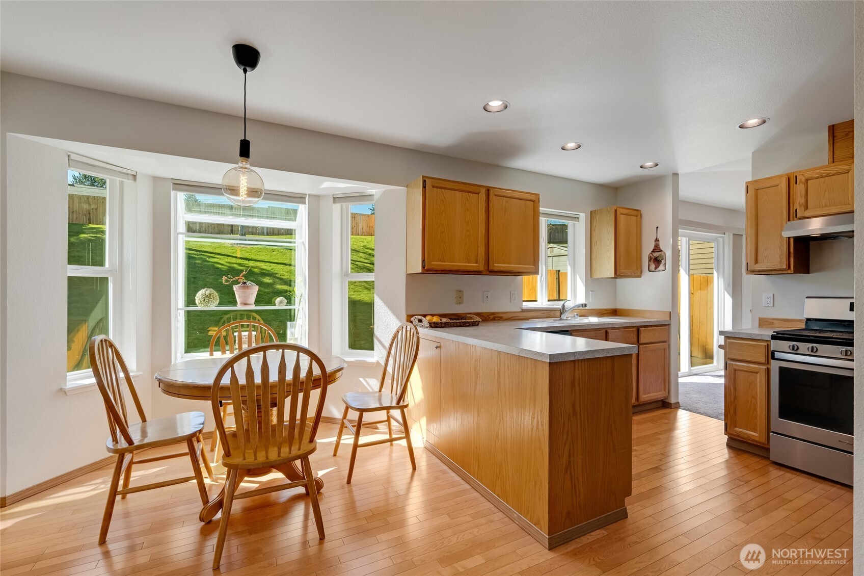 14 60th Place Southeast Everett, WA 98203 - Photo 8 of 35 a kitchen with stainless steel appliances granite countertop a stove top oven a refrigerator a kitchen island a dining table and chairs with wooden floor