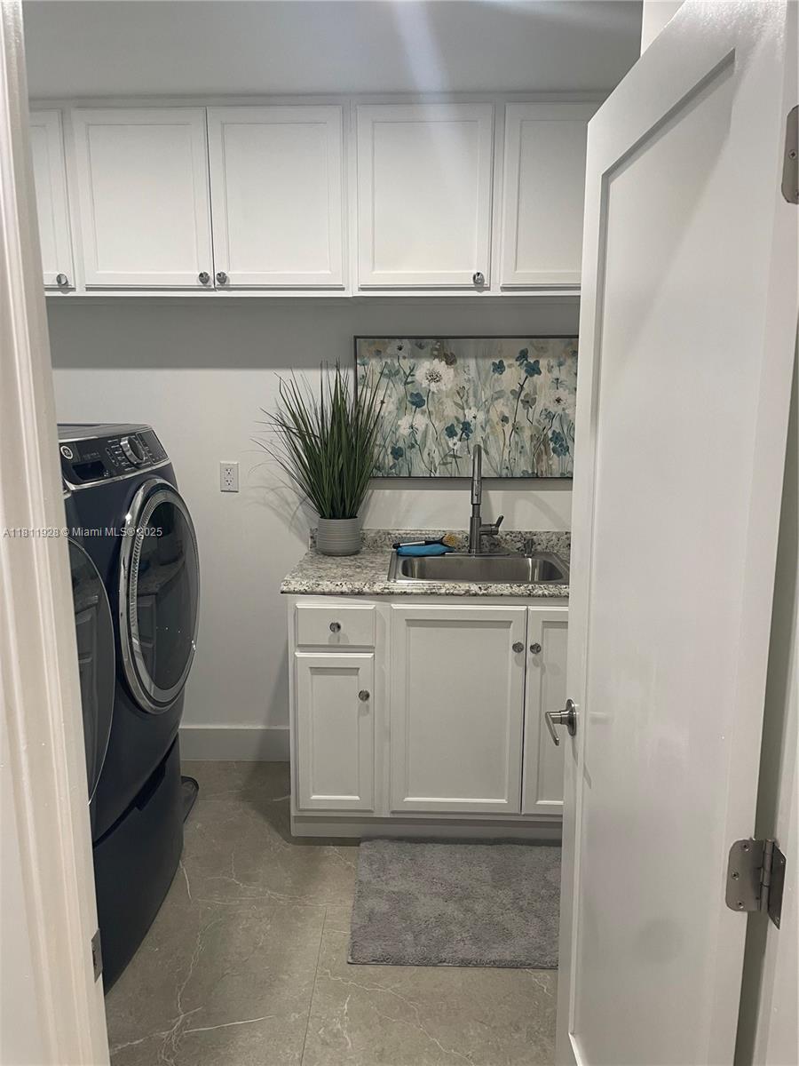 19700 Southwest 184th Street Miami, FL 33187 - Photo 12 of 52 a utility room with cabinets washer and dryer