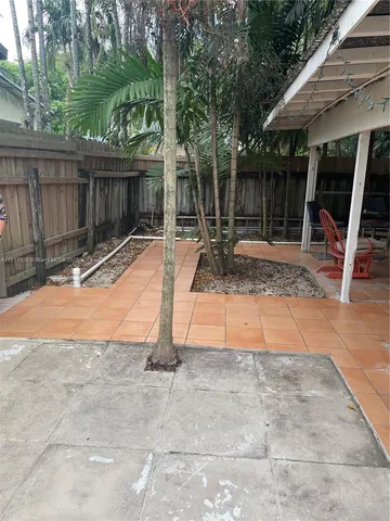 a view of backyard with a table and chairs and potted plants