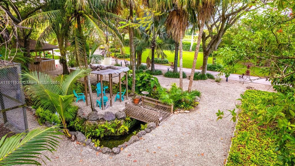 19700 Southwest 184th Street Miami, FL 33187 - Photo 43 of 52 a backyard of a house with a garden and outdoor seating