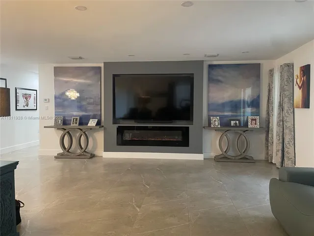 a living room with furniture and a dining table with wooden floor