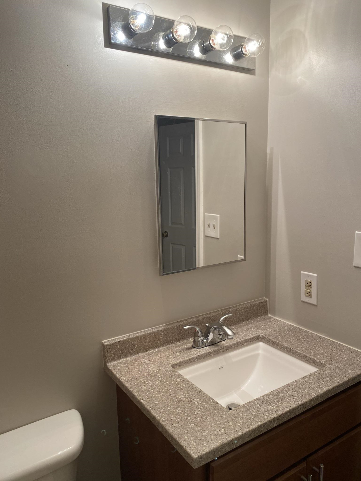 7717 Bernadette Lane Raleigh, NC 27615 - Photo 21 of 26 a bathroom with a granite countertop sink a toilet and mirror