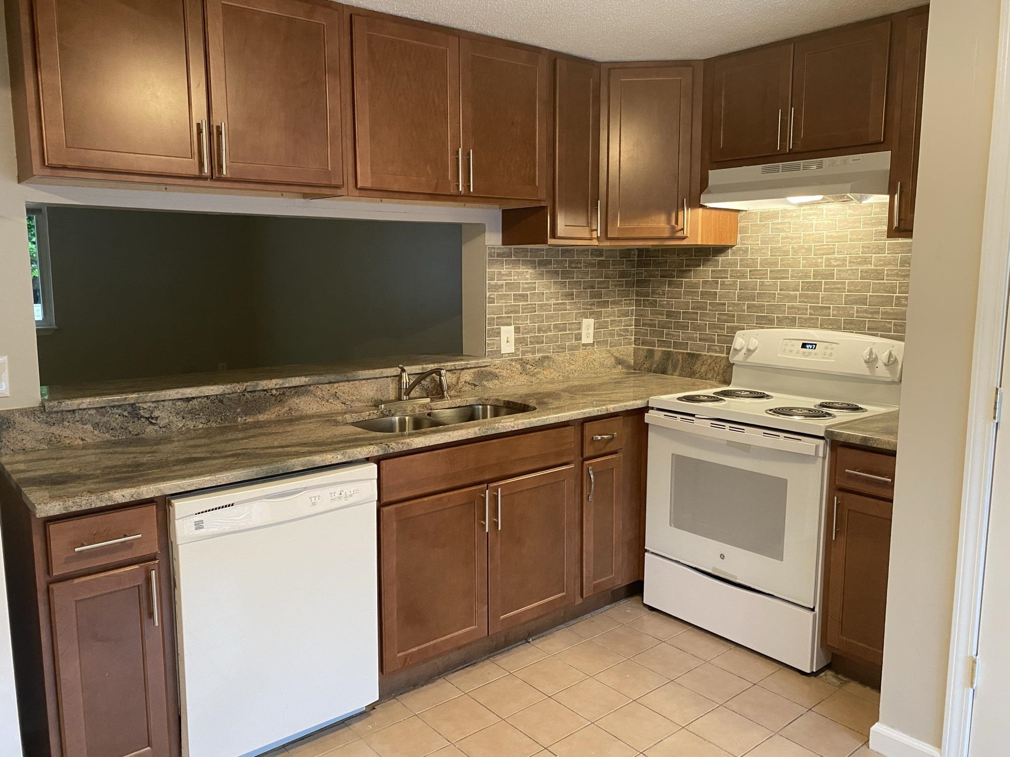 7717 Bernadette Lane Raleigh, NC 27615 - Photo 7 of 26 a kitchen with granite countertop cabinets stainless steel appliances and a sink