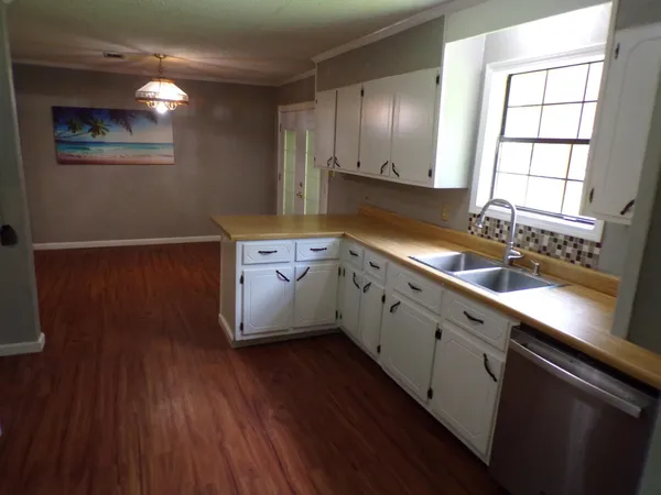 a kitchen with a sink window and cabinets