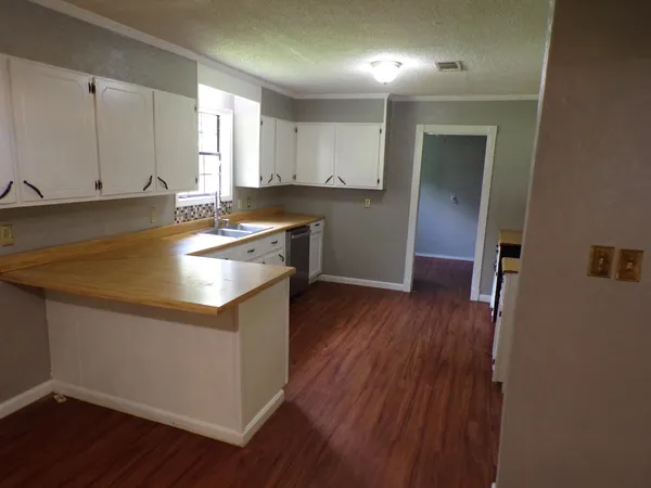 a kitchen with granite countertop a sink and wooden floor