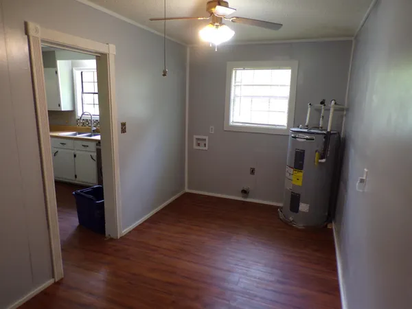 an empty room with wooden floor closet and windows