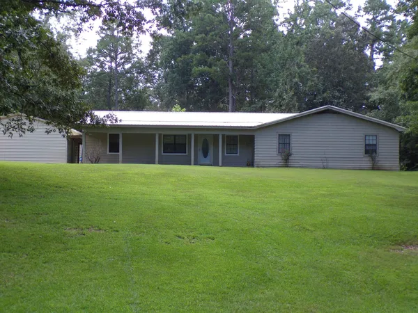 a view of a house with a yard and sitting area
