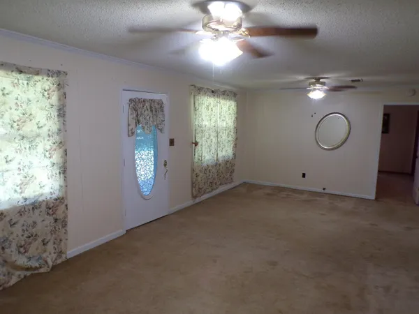 en empty room with windows and ceiling fan