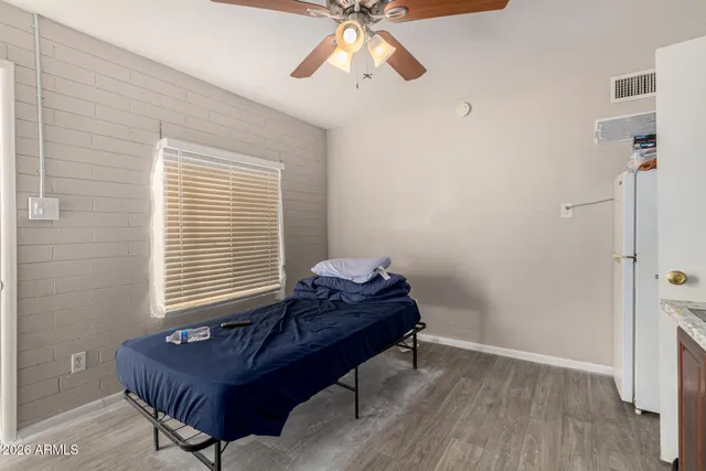 a bedroom with a bed and wooden floor