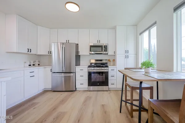a kitchen with cabinets stainless steel appliances and a window
